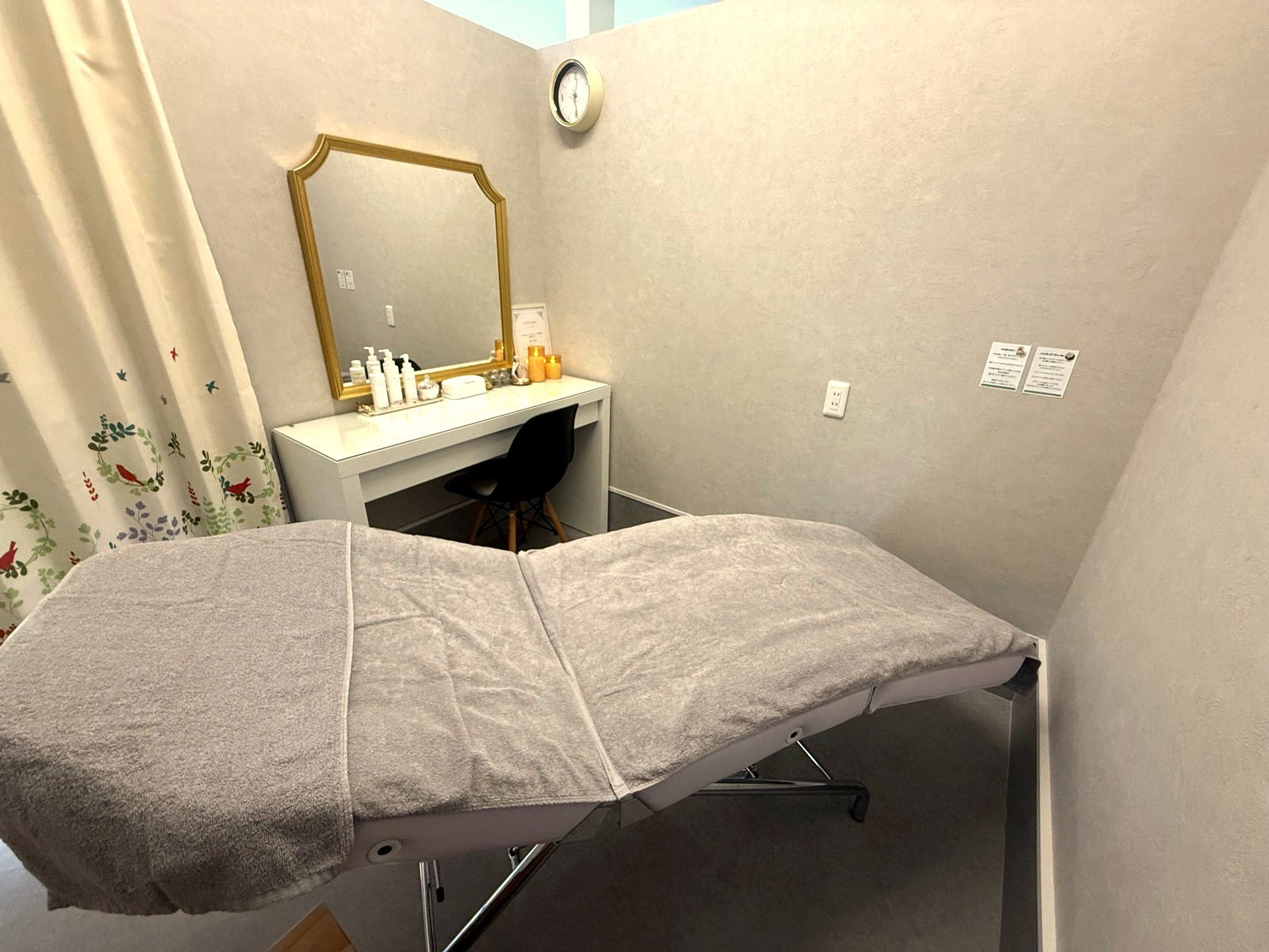 ゴールドの鏡とドレッサーのある施術空間